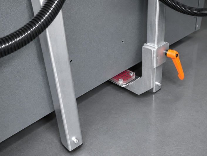 blechgreifer-detailansicht-fixierung-an-blechtafel Detailansicht eines Blechgreifers mit Fixierelement und orangefarbenem Spannhebel an einer großen Blechtafel.
