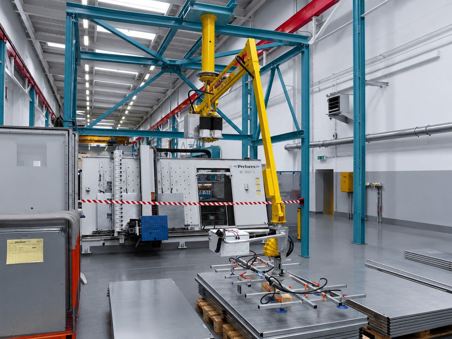 blechgreifer-vakuumgreifer-auf-blechstapel-in-fertigungshalle Blechgreifer mit Vakuumsaugern positioniert sich über einem Stapel großer Blechtafeln in einer industriellen Fertigungshalle.
