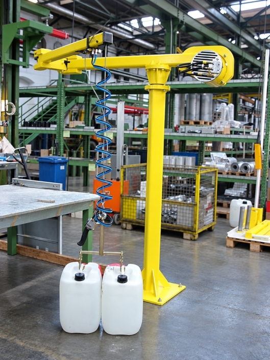 Fassmanipulator mit Fassgreifer zur gleichzeitigen Handhabung und zum ergonomischen Heben von zwei Kunststoffkanistern in einer Industriehalle.