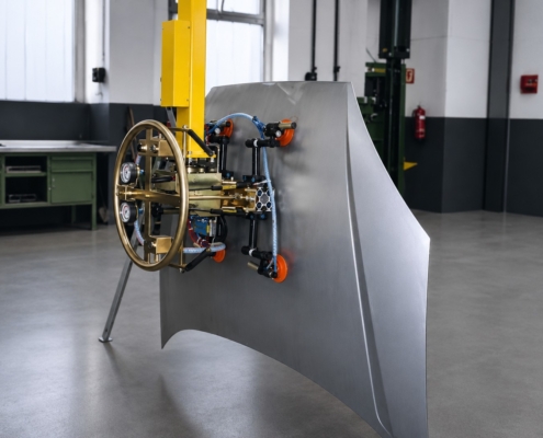 Vakuumsauger Blech mit Blechgreifer halten ein geformtes Metallblech mit orangefarbenen Saugnäpfen für das sichere Positionieren in der Fertigung.