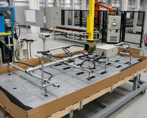 Vakuumsauger Blech mit Blechgreifer halten ein großes strukturiertes Metallblech auf einer Palette für das sichere Handling in der Fertigung.