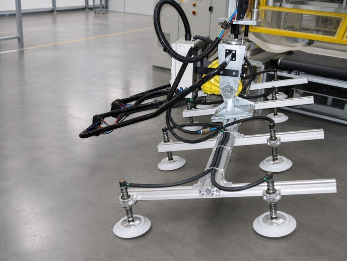 Detailansicht eines Vakuumsaugers für Bleche mit Saugrahmen, weißen Saugnäpfen und pneumatischen Leitungen für das sichere Handling von Bauteilen.